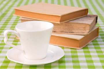 Cup with books on the table.