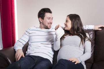 Mid-adult woman expecting baby lying on sofa