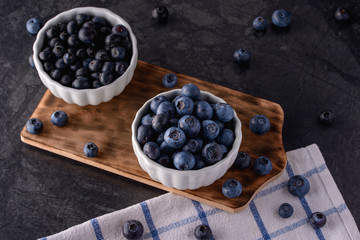 Blueberry in bowls on black background, healthy food concept
