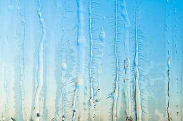 Ice flowers and frost pattern on frosty window glass
