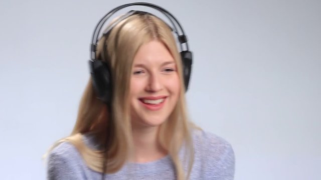 Blonde girl with headphones listening to music