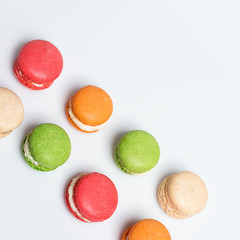 Colorful macaroons isolated on white with space for text. Traditional french dessert. Top view, flat lay.