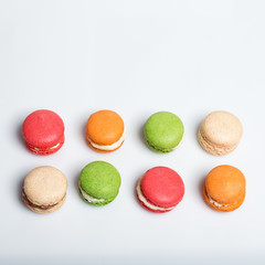 Colorful macaroons isolated on white with space for text. Traditional french dessert. Top view, flat lay.