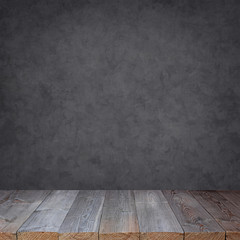 Empty wooden table against a grey wall.