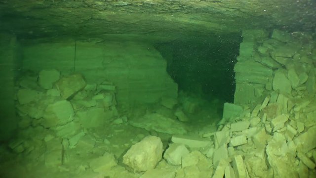 The camera moves through a translucent suspension of mold raised from the bottom of flooded mine by the diver.

