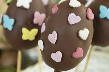 Detail of chocolate Easter eggs with heart and butterfly shaped candies.