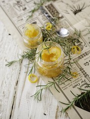 orange marmalade in small glass jars with rosemary, selective focus