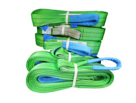 Green nylon soft lifting slings stacked in piles.