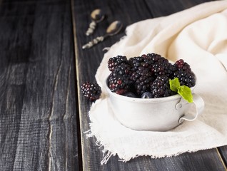 fresh raw blackberries in metal cup, selective focus