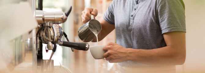 Barman preparing latte beside machine