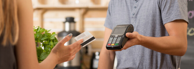 Woman paying with debit card - obrazy, fototapety, plakaty