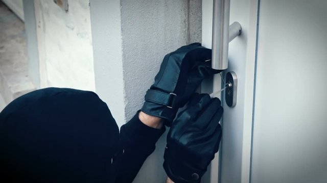 Einbrecher &ouml;ffnet Haust&uuml;re mit Lock picking Werkzeug