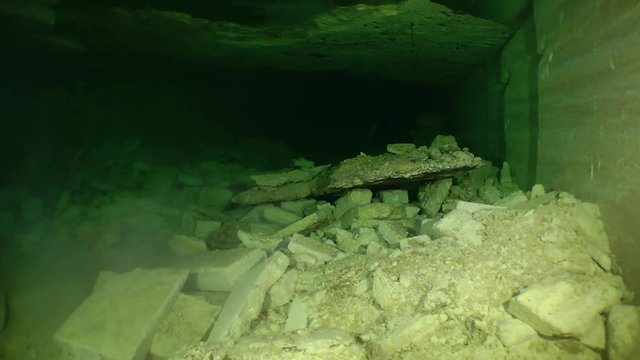 Limestone rock formations falls from the ceiling in the flooded mine.

