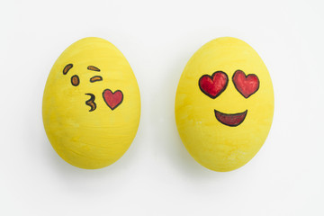 Painted emoji easter eggs in different moods and facial expressions such as kissing, smiling or being in love, in isolated white background.