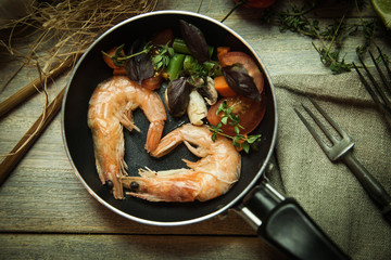 Romantic dish: prawns with colorful bell peppers, vegetables, basil, tomatoes in pan with sauce in St Valentines day