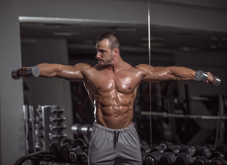 Fototapeta na wymiar Handsome muscular man in gym.