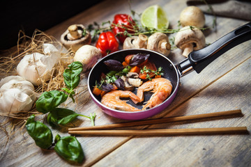 Romantic dish: prawns with colorful bell peppers, vegetables, basil, tomatoes in pan with sauce in St Valentines day