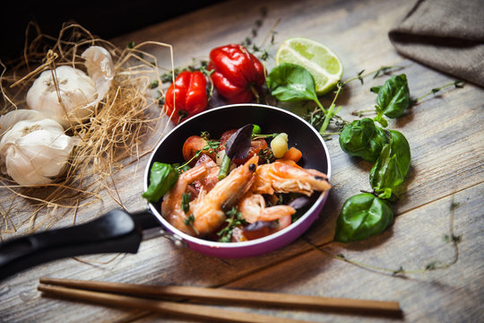 Romantic dish: prawns with colorful bell peppers, vegetables, basil, tomatoes in pan with sauce in St Valentines day