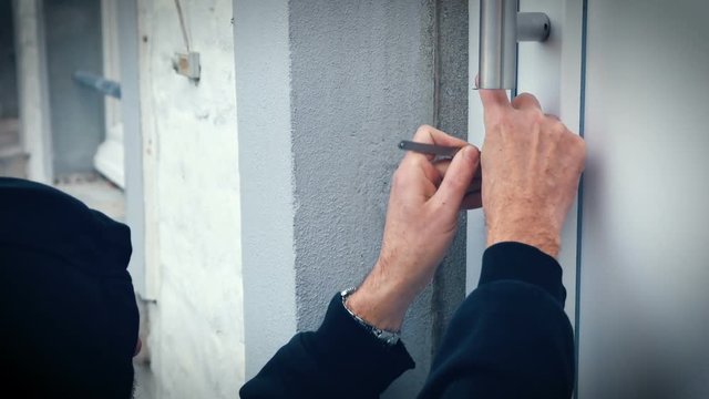 Einbrecher &ouml;ffnet Haust&uuml;re mit Lock picking Werkzeug