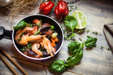 Romantic dish: prawns with colorful bell peppers, vegetables, basil, tomatoes in pan with sauce in St Valentines day
