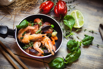 Romantic dish: prawns with colorful bell peppers, vegetables, basil, tomatoes in pan with sauce in St Valentines day