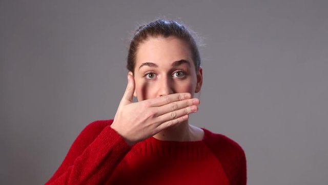 beautiful young woman covering her mouth for reaction to mistake