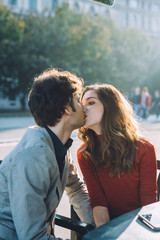 Young beautiful couple in love kissing outdoor in back light - love, relationship, kiss concept