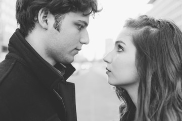 Young beautiful couple in lov outdoor in the city looking the eye - love, romantic, relationship concept. Black and white