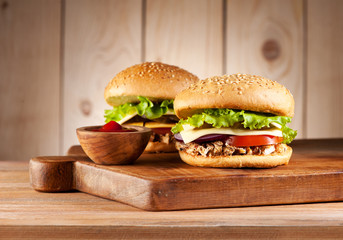 Burgers hamburgers with meat turkey, cheese and vegetables on a rustic background