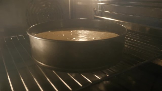 Dessert pot being heated in greasy electric oven slow tilt 4K 2160p 30fps UltraHD footage - Modern stove apple pie baking close-up 