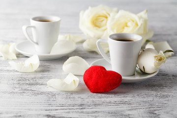 Two cups and felt hearts on light background