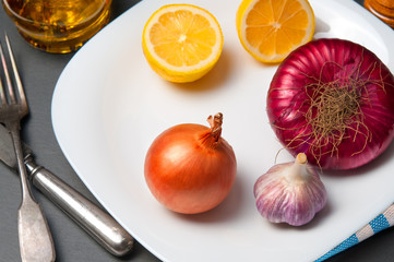 Ingredients: onion, garlic, lemon on white plate