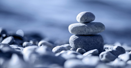 Website banner of Zen balancing pebbles on the beach in blue