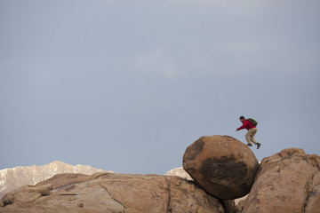 A man hiking on huge boulders in the Sierra Nevada Mountains, near Lone Pine, California.