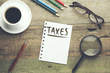Taxes text on notebook with coffee