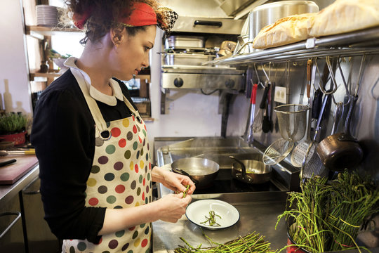 Female chef preparing food in frying pan