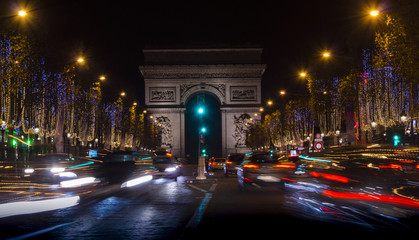Fototapeta na wymiar Champs Elysees in Paris illuminated for Christmas and Triumphal Arch in background