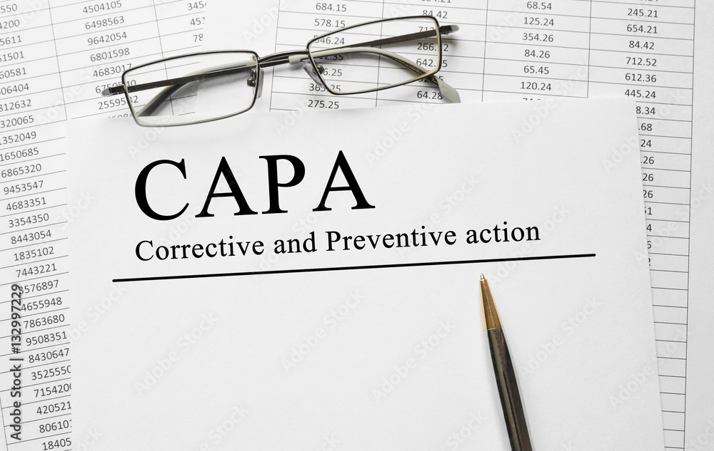 Poster paper with corrective and preventive (capa) action plans on a table