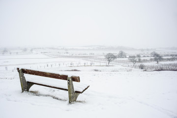 Landschaft mit Bank im Schneefall