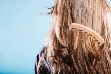 Crédence de cuisine en verre imprimé Salon de coiffure Straight brown hair with wooden comb closeup