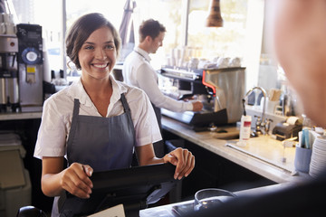 Woman Takes Customer Order In Coffee Shop