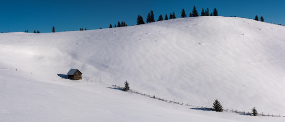 Hut in the mountains. Idyllic winter landscape with small house. 