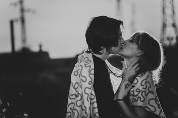 black and white guy  the girl are standing against the sunset in a plaid