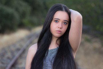 Portrait of young woman standing on railroad track