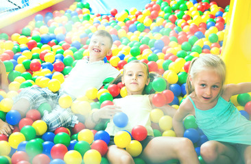 Fototapeta na wymiar children playing together in pool with plastic multicolored ball