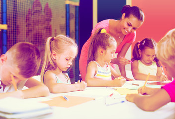 Fototapeta premium children sitting together and drawing in class at school