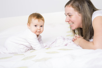 Portrait of a crawling baby on the bed in her room