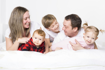 five member Young Family Having Fun In Bed