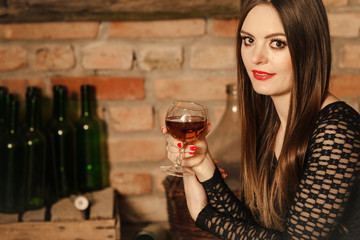 Woman tasting wine in rural cottage interior