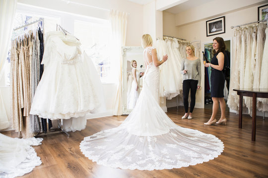 Female customer in bridal shop trying on wedding dress